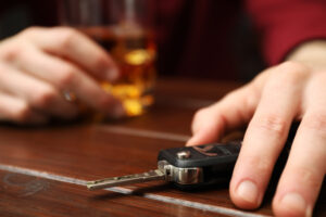 Man holding car key while getting drunk