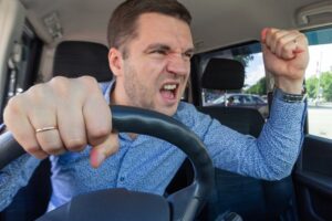 Road rage: man in car gesturing angrily